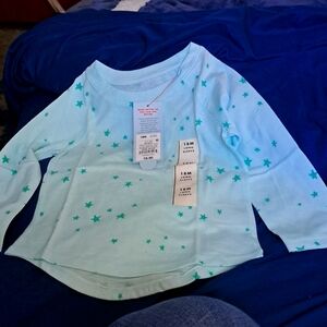Long-sleeved Size 18 months T shirt. Mint background with green stars all over.